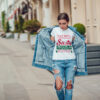 Attractive girl in a jeans jacket and white t-shirt walking along the street. Mock-up. FIESTAS PATRIAS