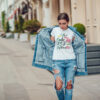 Attractive girl in a jeans jacket and white t-shirt walking along the street. Mock-up. FIESTAS PATRIAS
