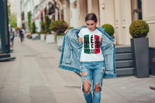 Attractive girl in a jeans jacket and white t-shirt walking along the street. Mock-up. FIESTAS PATRIAS