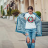 Attractive girl in a jeans jacket and white t-shirt walking along the street. Mock-up. FIESTAS PATRIAS