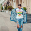 Attractive girl in a jeans jacket and white t-shirt walking along the street. Mock-up. FIESTAS PATRIAS