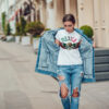 Attractive girl in a jeans jacket and white t-shirt walking along the street. Mock-up. FIESTAS PATRIAS