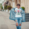 Attractive girl in a jeans jacket and white t-shirt walking along the street. Mock-up. FIESTAS PATRIAS