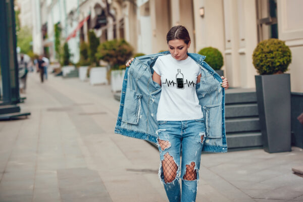 Attractive girl in a jeans jacket and white t-shirt walking along the street. Mock-up. FIESTAS PATRIAS