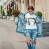 Attractive girl in a jeans jacket and white t-shirt walking along the street. Mock-up. FIESTAS PATRIAS
